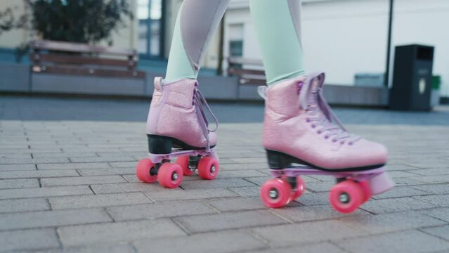 Close up shot of young woman riding quad rollers skates in city. Happy riding retro rollerskates