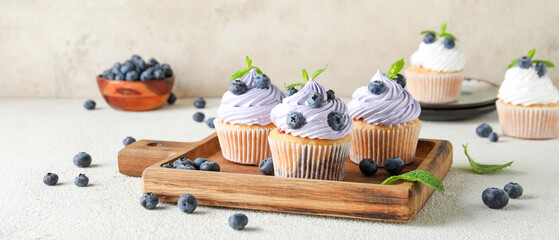 Delicious blueberry cupcakes on table