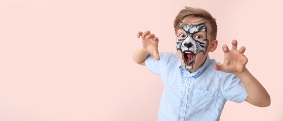 Funny little boy with face painting on pink background with space for text