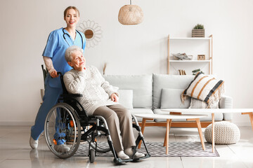 Young caregiver with senior woman in wheelchair at home