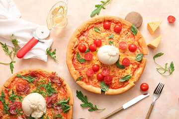 Tasty pizzas with Burrata cheese on beige background