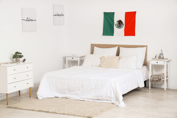 Interior of bedroom with tables and hanging Mexican flag