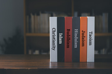 Book spines listing major world religions - Christianity, Islam, Hinduism, Buddhism, Taoism and Judaism. religion concept. - obrazy, fototapety, plakaty