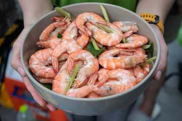 Cropped shot of someone holding boiled shrimps. Steaming, instead of boiling, is a more gentle method of cooking shrimp.