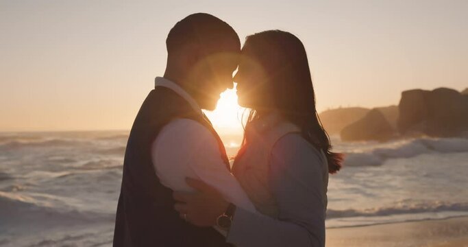 Couple at the beach, sunset and silhouette with people in relationship, forehead touch or hug by the ocean. Travel, love and romance with vacation, trust and together outdoor with peace and calm
