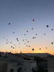 Aerial view of a fleet of hot air balloons,  Cappadocia, Turkey, at sunrise. Cappadocia is a popular tourist destination.