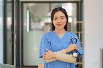 Portrait of a professional female doctor with a stethoscope standing with crossed arms.