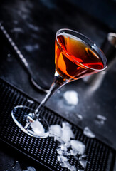 Bobby Burns strong cocktail drink with scotch whiskey, vermouth and liquor in martini glass, dark bar counter background