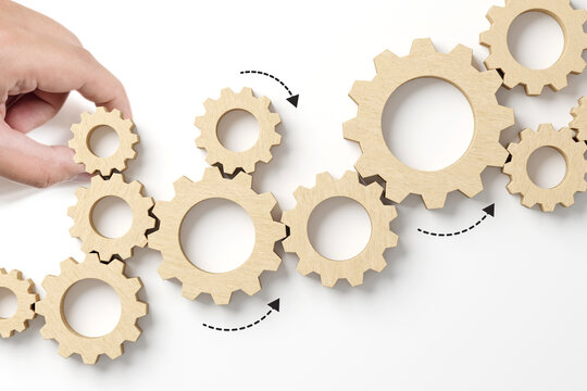 Business process and workflow automation with flowchart. Hand holding wooden cog flowing process management on white background