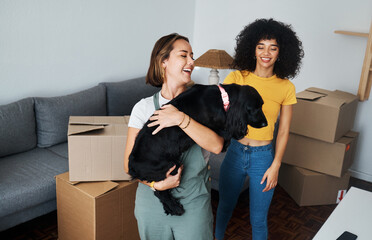 Moving, lesbian and couple with dog in new home, boxes and smile in real estate together. Property, mortgage and lgbt women with puppy in living room happy and excited for pet, love and house