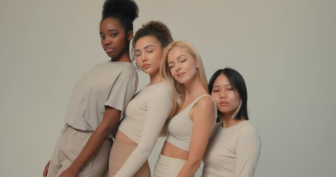 multiracial women putting head on each other's shoulders, support Slow motion Beauty portrait of group of diverse sensual young girl, skin care, diversity and friendship and teamwork, camera whirling