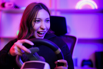 Asian young driver girl excited and fun when playing video game about speed car competition and use...