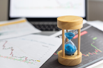 Hourglass on laptop computer concept for time management and countdown to deadline