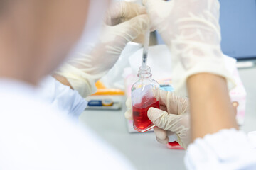Scientist distilled solvent water from glass bottle for clinical samples in laboratory. Lab...