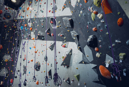 Artificial climbing wall with colorful grips and ropes