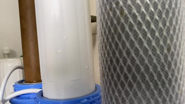 Focus shifting shot. Dirty water purifier filters close up view at home on kitchen sink. Health and well being concept