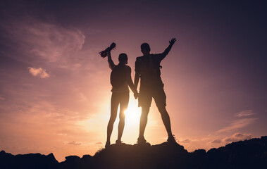 Fototapeta premium Happy young couple climbs to the top in the mountains near the ocean