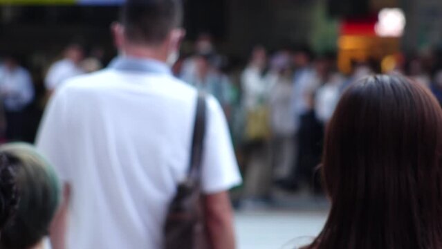 Slow motion shot of crowd of people walking in Osaka, Japan. Back shot of unidentified men and women. Shot in sunset time, busy rush hour. Japanese people and urban city lifestyle concept video.