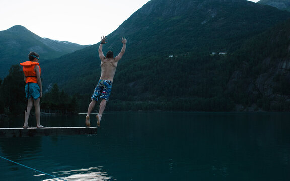 dad jumping into a Norwegian Fjord with his son