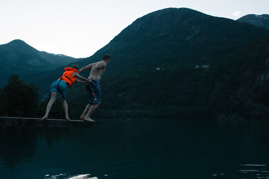 son pushing his father off a diving board into a Norwegian Fjord