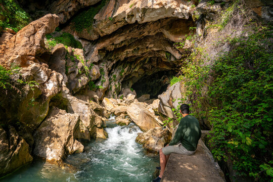 Man in Cueva del Gato cave with a waterfall in Andalusia, Spain