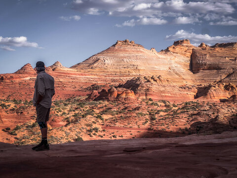 A male hiker looks out over the Wave in Vermilion Cliffs