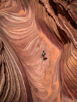 A solitary male hiker inside the famous Wave in North Coyote Buttes