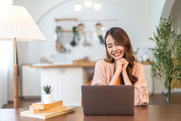 Young smiling asian woman happy relax use laptop conference work,learning education, shopping, study online, webinar, podcast,creative girl feel good, positive, success, excited, surprised at home