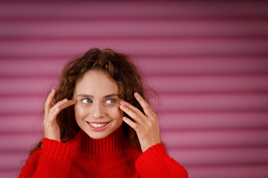 Young red haired woman touching face with fingers doing face yoga facial gymnastics self massage and facebuilding exercise