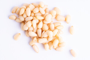 Pine nuts pile and separate kernels on white background.