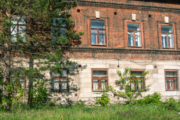 An old brick house built in the 19th century. Architecture of the last century. A residential building built in the last century. The first floor of an old house built of limestone blocks.