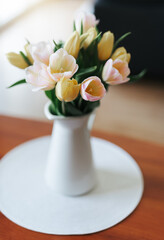 Spring tulips in a vase on the table. Spring holiday, home decor.