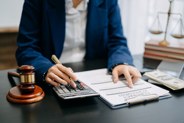 justice and law concept.businessman or lawyer or accountant working on accounts using a smart phone laptop digital tablet calculator and documents in modern office .