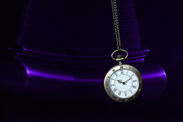 Hypnosis session. Vintage pocket watch with chain swinging over surface on dark background among...