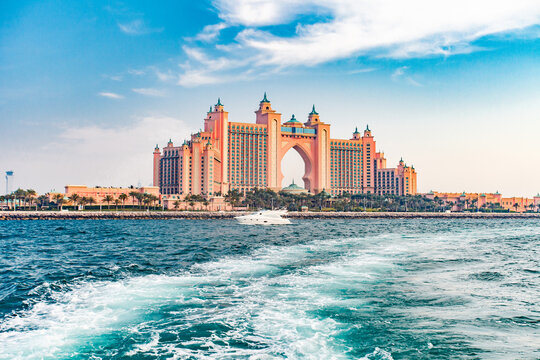 Dubai, UAE – april 11, 2023: Palm Jumeirah, Atlantis The Palm, white yacht sailing on water, trees