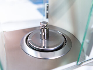 Close-up of metal weight to calibrate on a balance in a laboratory.