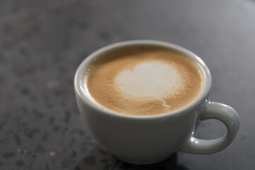 Fresh cup of cappuccino on concrete countertable