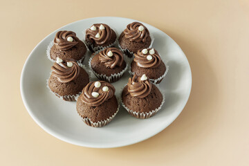 Mini chocolate cupcakes on a plate on an orange background