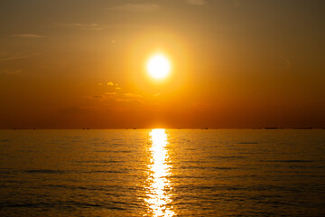 東京湾のさざ波に揺れる夕焼けの太陽の光