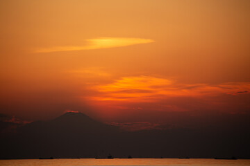 夕焼けに浮かび上がる茜雲と富士山のシルエット