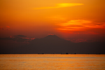 夕焼けに浮かび上がる富士山と茜雲のシルエット - obrazy, fototapety, plakaty