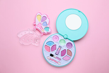 Decorative cosmetics for kids. Eye shadow palettes on pink background, top view