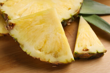 Slices of ripe juicy pineapple on wooden board, closeup