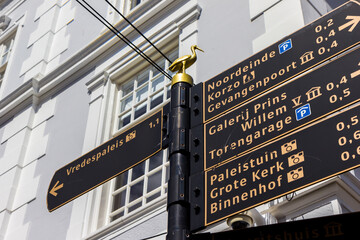 Tourist sign with a golden stork on top in historic city Den Haag, Netherlands