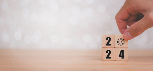 2024 on wooden table. Wooden cubes with 2024 and goal icon on neutral grey background. Starting to new year 2024 with goal plan, goal concept, action plan, strategy, new year business vision.