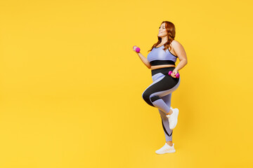 Fototapeta na wymiar Full body side profile view smiling young chubby plus size big fat fit woman wear blue top warm up training hold dumbbells isolated on plain yellow background studio home gym. Workout sport concept.