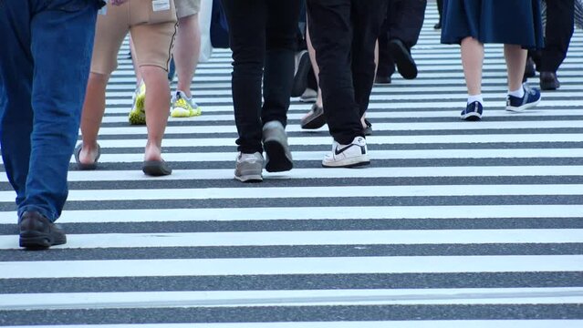 TOKYO, JAPAN - JULY 2023 : Crowd of people walking at the street near Shinjuku station in busy rush hour. Japanese people, urban city life and lifestyle concept video. Slow motion shot.