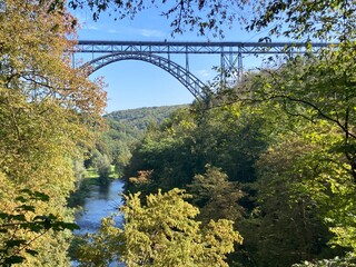 Blick auf die Müngstener Brücke mit Fluss Wupper durch die Bäume im Wald im Herbst - 648842892