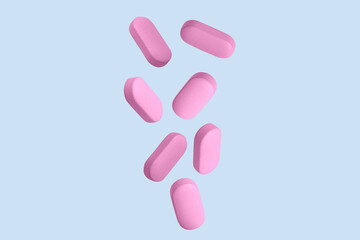 Pink capsules, pills and tablets. On.blue background.