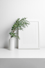White artwork frame mockup in minimalistic room interior with green plant decor, frame mock up with copy space